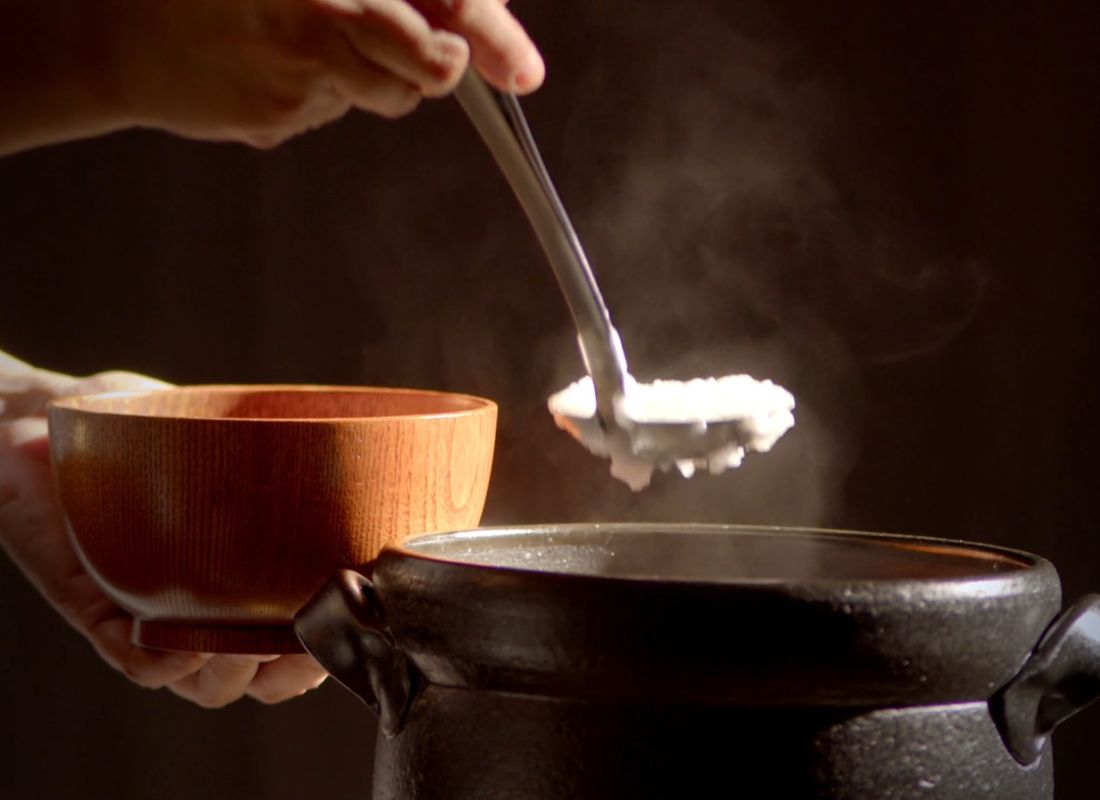 osoba uzima pirinač sa kutlačom iz šerpe